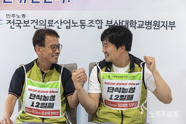 ▲ 2019년 7월 정재범 부산대병원 지부장(정규직)과 손상량 시설분회장(비정규직)이 인터뷰 중에 서로를 바라 보고 웃고 있다.[사진 : 노동과 세계]