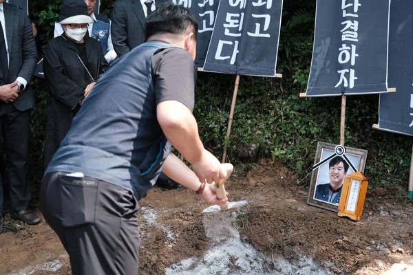 강규혁 서비스연맹 위원장이 故 김태완 동지의 무덤에 취토 하고 있다.