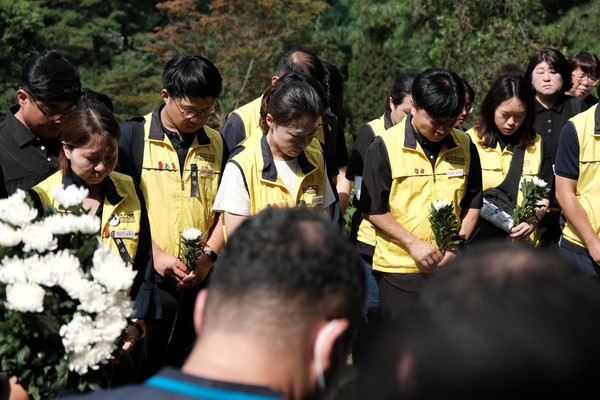 故 김태완 동지의 무덤 앞에서 마트노동자들이 마지막 묵념을 하고 있다. 