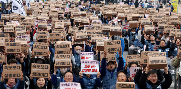 23일 오후 서울 종로구 동십자각 앞에서 열린 '과로사 없는 택배 만들기 시민대행진'에서 택배 노조원들이 구호를 외치고 있다.